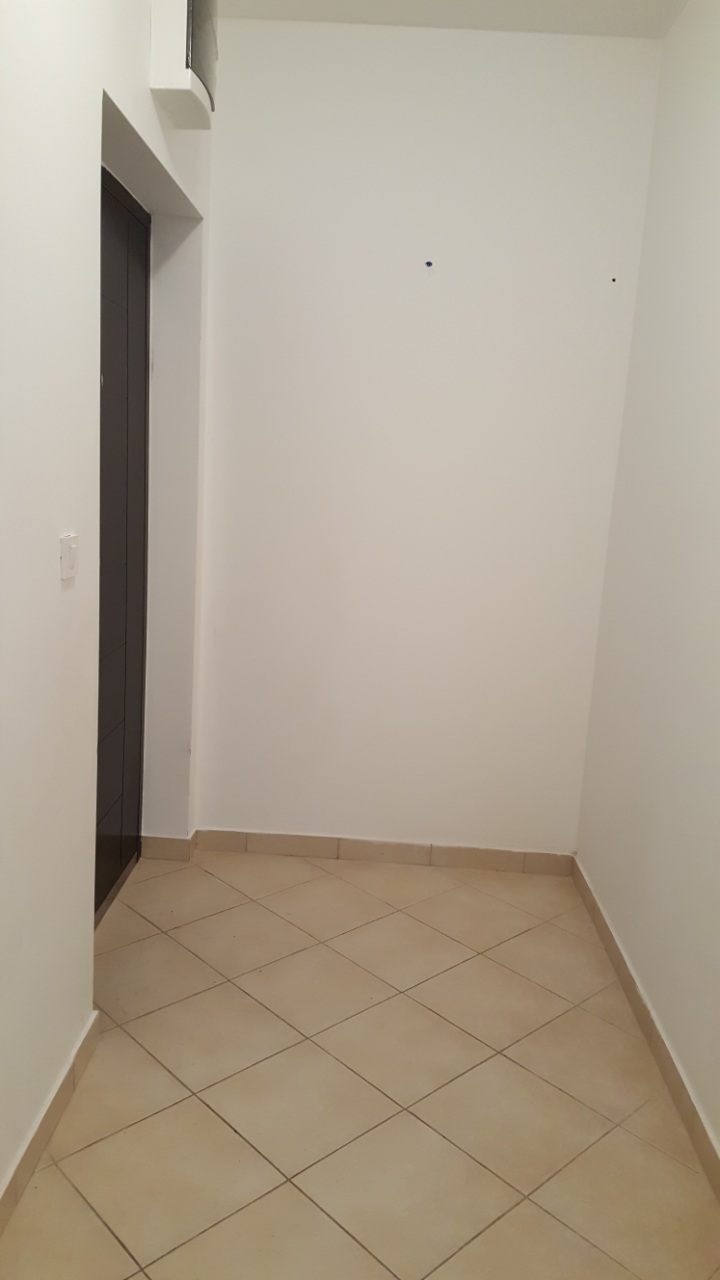 Budva, Karadağ’daki dairede aydınlık koridor: beyaz duvarlar, yer karoları ve koyu renkli iç kapı.