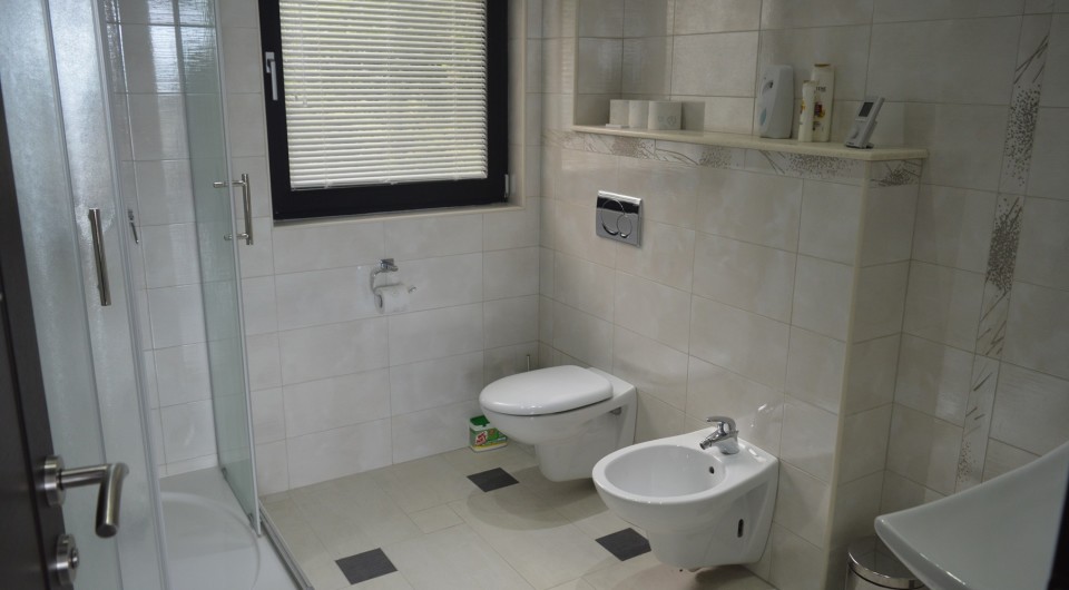 Tivat, Karadağ’daki villada duş kabini ve bideli modern banyo, açık renkli fayanslar ve kaliteli sıhhi tesisat