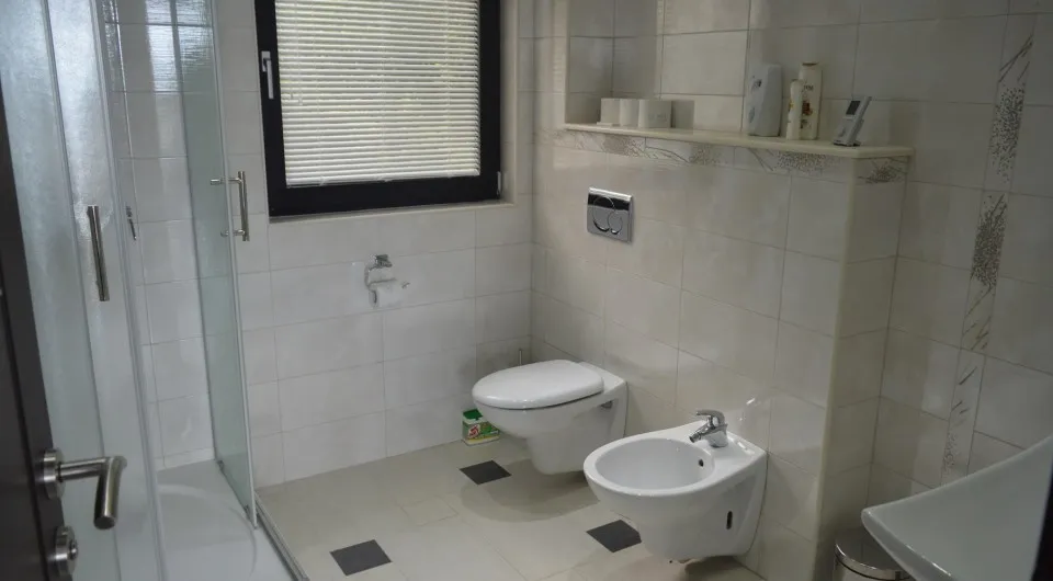 Modernes Badezimmer mit Duschkabine und Bidet in einer Villa in Tivat, Montenegro, helle Fliesen und hochwertige Sanitäranlagen