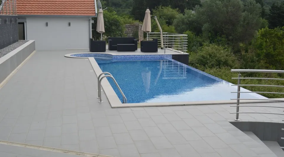Offener Pool mit Terrasse und Ruhebereich in einer Villa in Tivat, Montenegro: moderne Ausstattung und Blick ins Grüne.