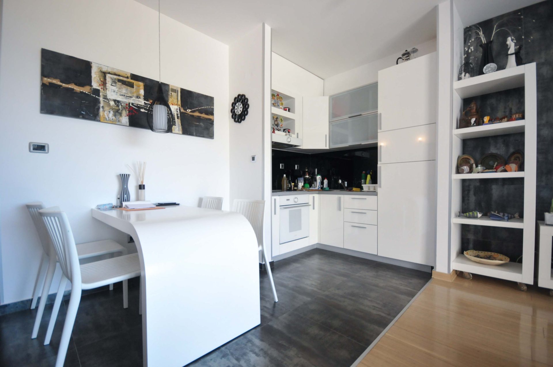 Moderne Wohnküche mit weißer Einbauküche in einer Wohnung in Pržno, Montenegro: Essbereich und stilvolles Interieur.