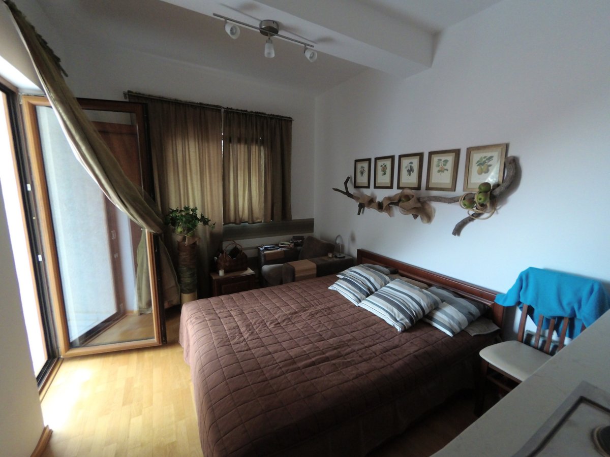 Udobna spavaća soba sa bračnim krevetom u stanu u Budvi, Crna Gora: svetao enterijer, izlaz na balkon i dekor.