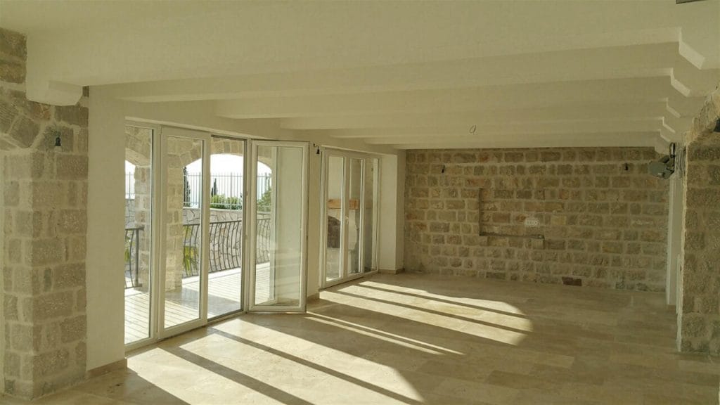 Karadağ, Drobny Pesak’taki villada taş duvarlı ve panoramik pencereli geniş oturma odası.