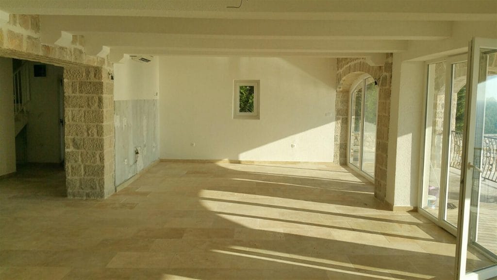 Karadağ, Drobny Pesak’taki villada taş kaplamalı ve panoramik pencereli geniş oturma odası.