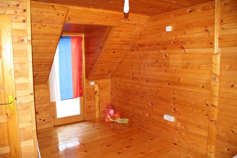 Chambre à coucher dans une maison à Sutomore, Monténégro : pièce mansardée avec finition complète des murs et du sol en bois naturel.