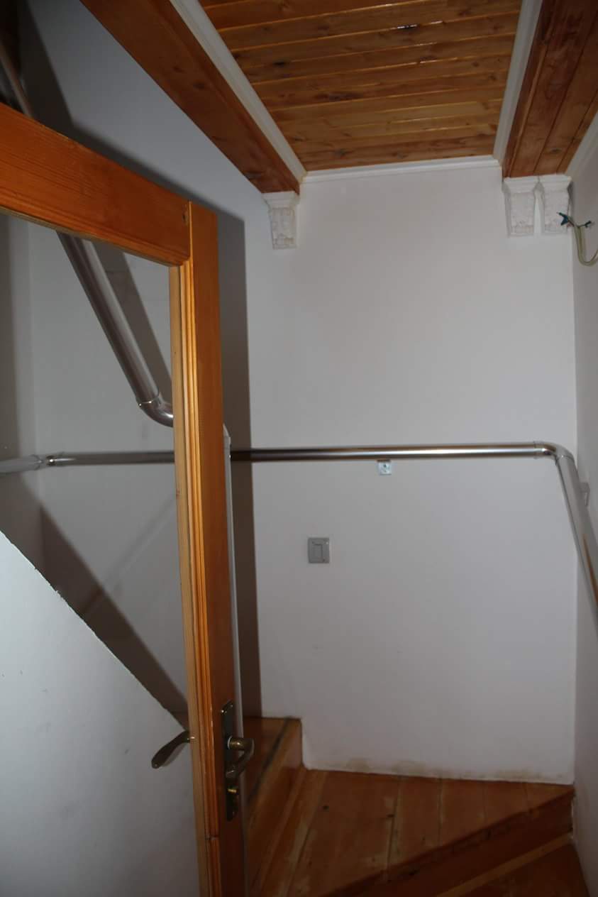 Escalier avec marches en bois et rampe en métal dans une maison, ville de Sutomore, Monténégro.