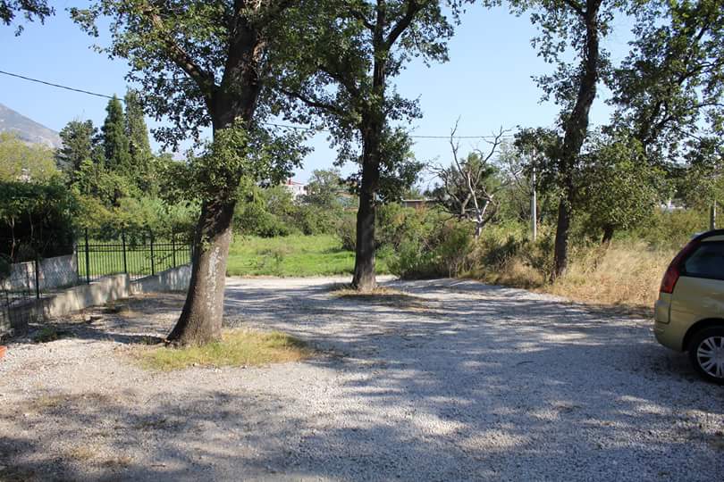 Terrain avec parking en gravier et arbres près de la maison à Sutomore, Monténégro.