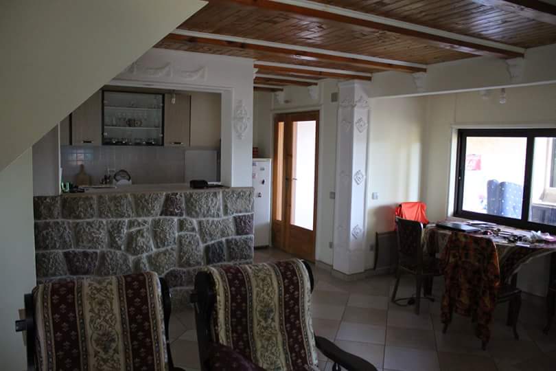 Salon avec comptoir de bar en pierre et plafond en bois dans une maison à vendre, Sutomore, Monténégro.