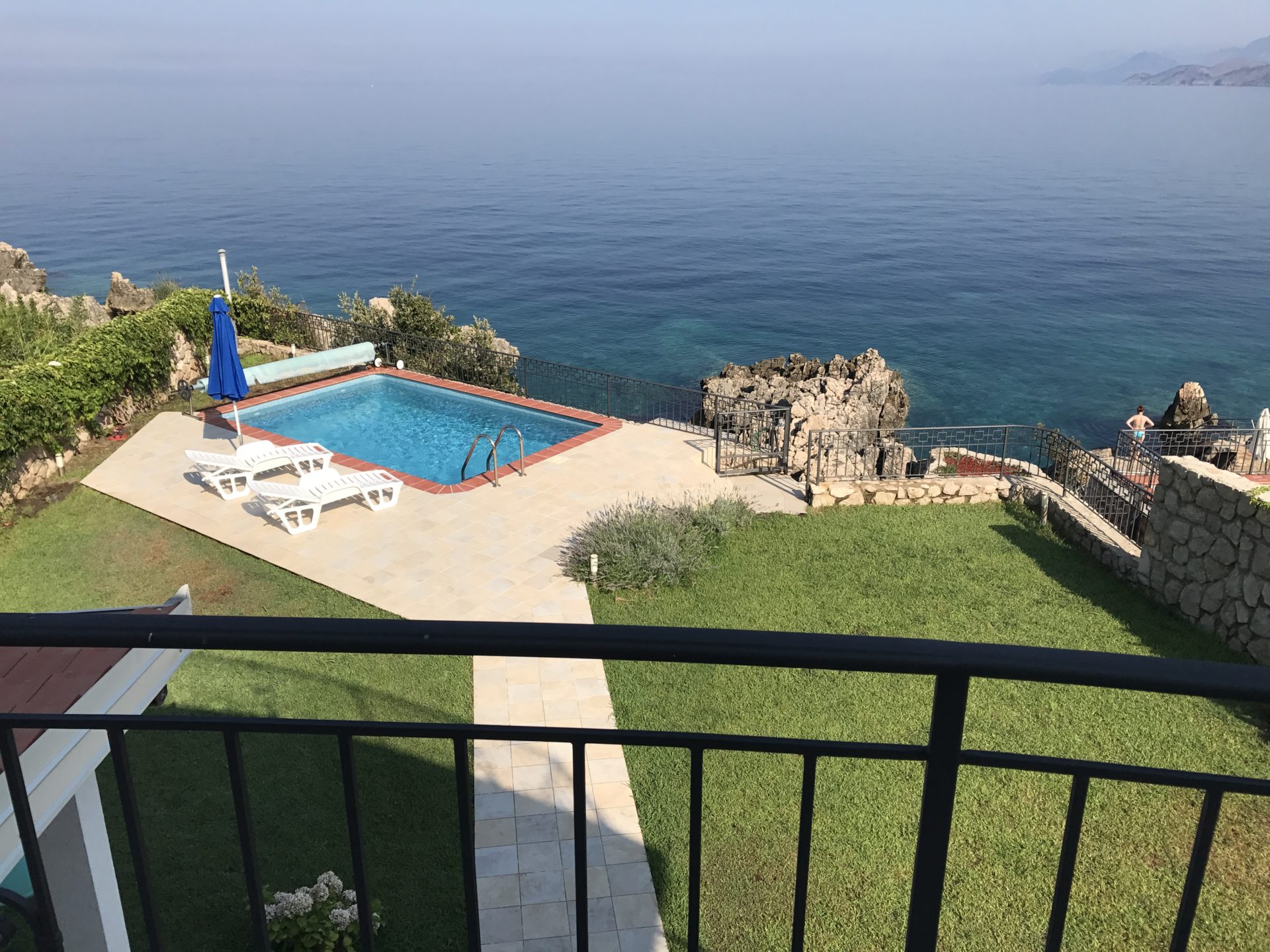 Pool am Meer auf einer Villa in Utjeha, Montenegro: Terrasse mit Liegestühlen, grüner Rasen und Panoramablick auf die Adria.