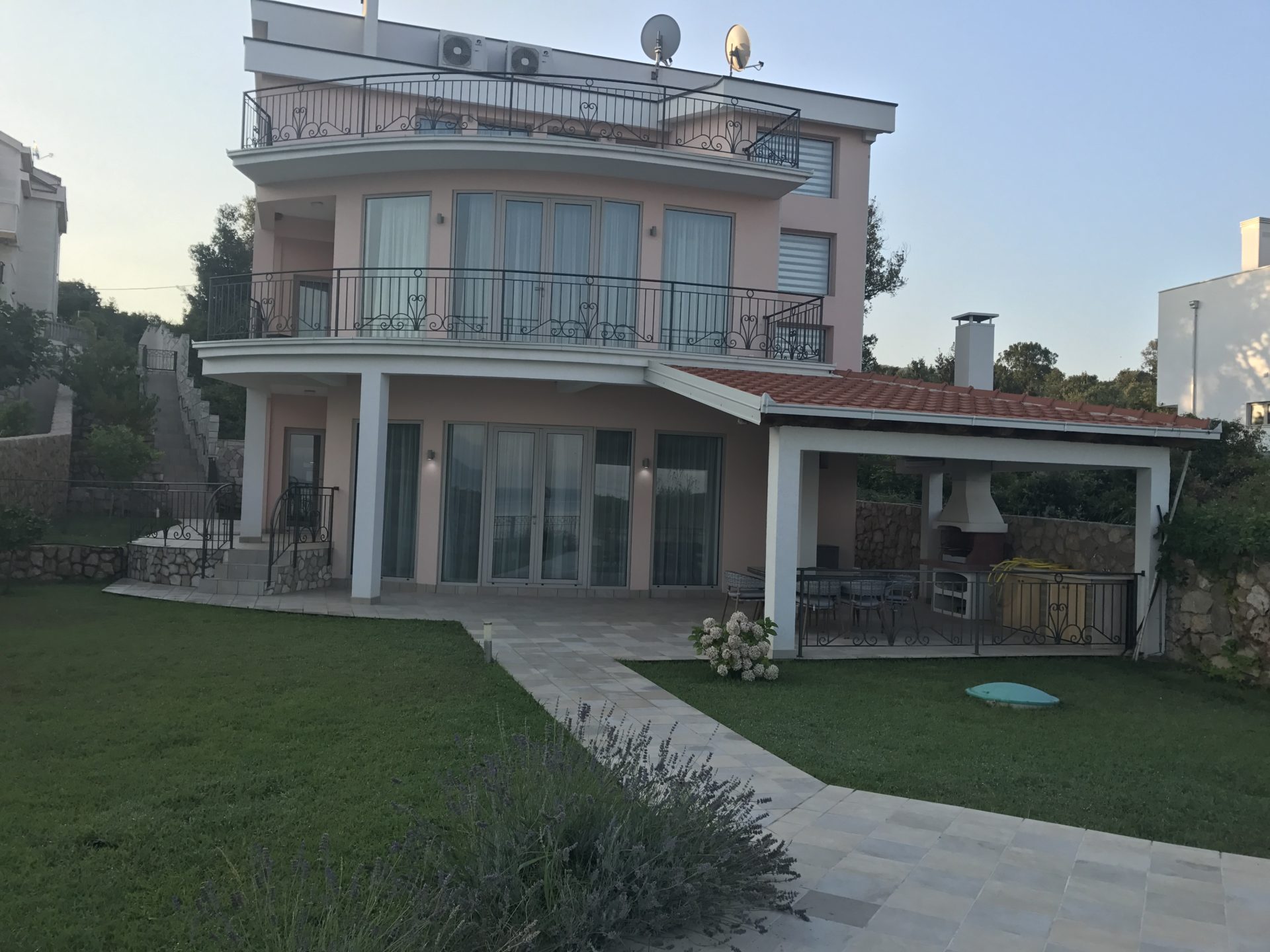 Dreistöckige Villa in Utjeha, Montenegro: Fassade mit Terrassen, Panoramafenstern, Grillbereich und gepflegtem Garten.