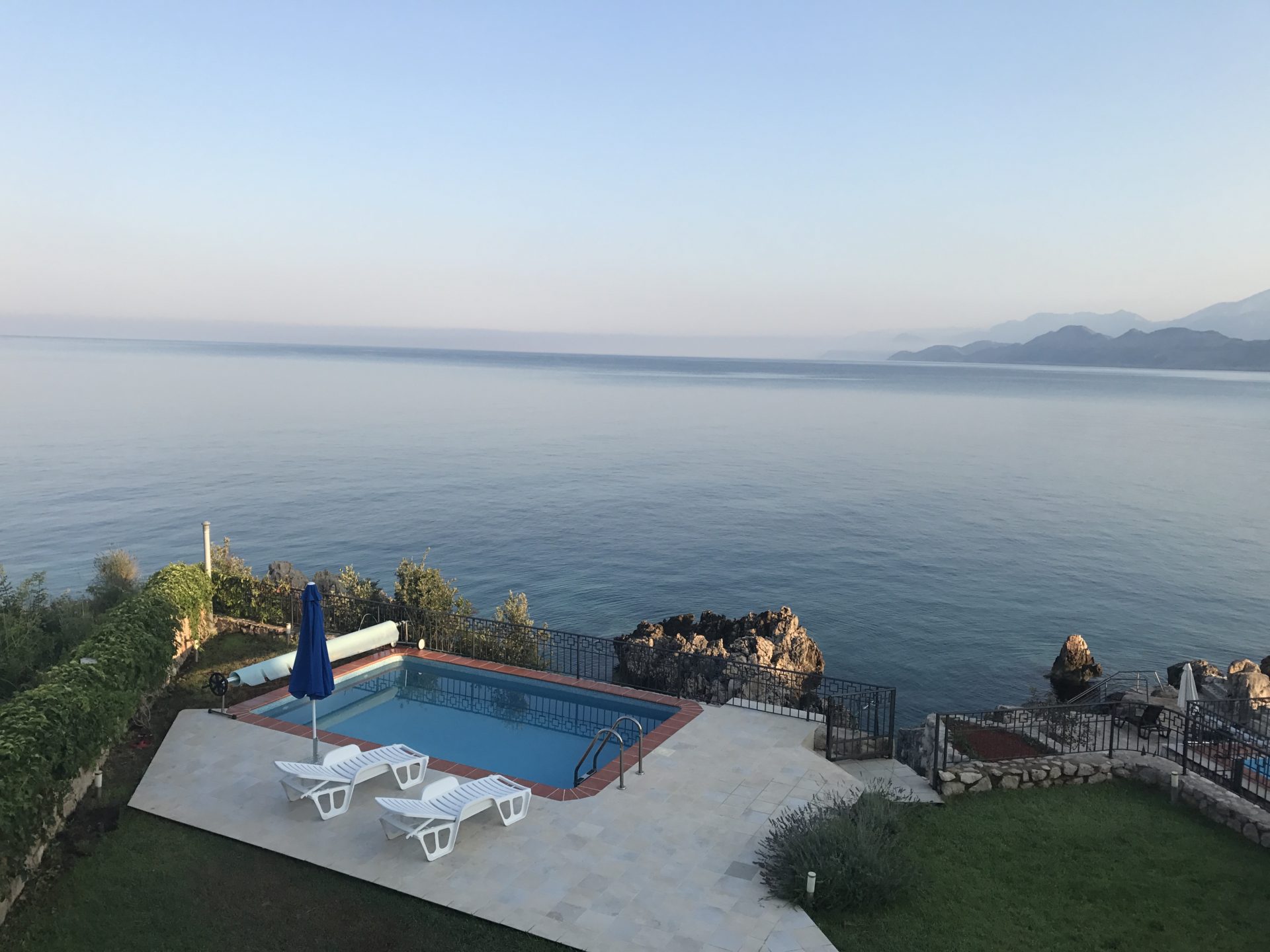 Offener Pool mit Liegestühlen und Panoramablick auf das Meer bei der Villa in Utjeha, Montenegro.