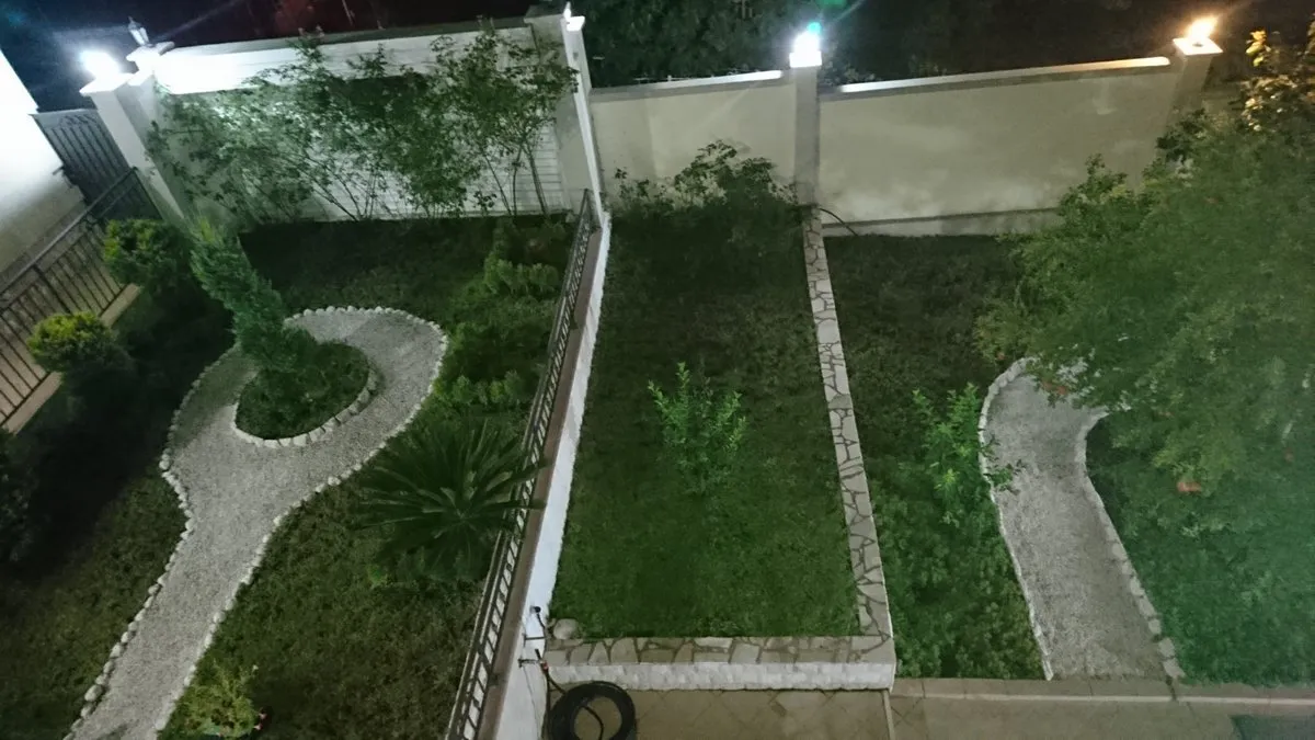 Well-maintained landscaped garden with lighting at a villa in Utjeha, Montenegro: gravel paths and a green lawn.