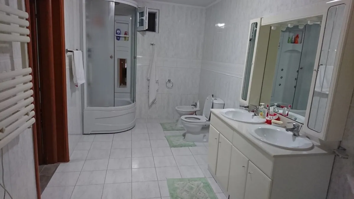 Spacious bathroom in a villa in Utjeha, Montenegro: shower cabin, bidet, toilet, and vanity with double sink.