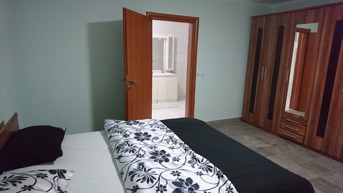 Schlafzimmer mit Doppelbett, Kleiderschrank und Zugang zum Badezimmer in einer Villa in Utjeha, Montenegro.