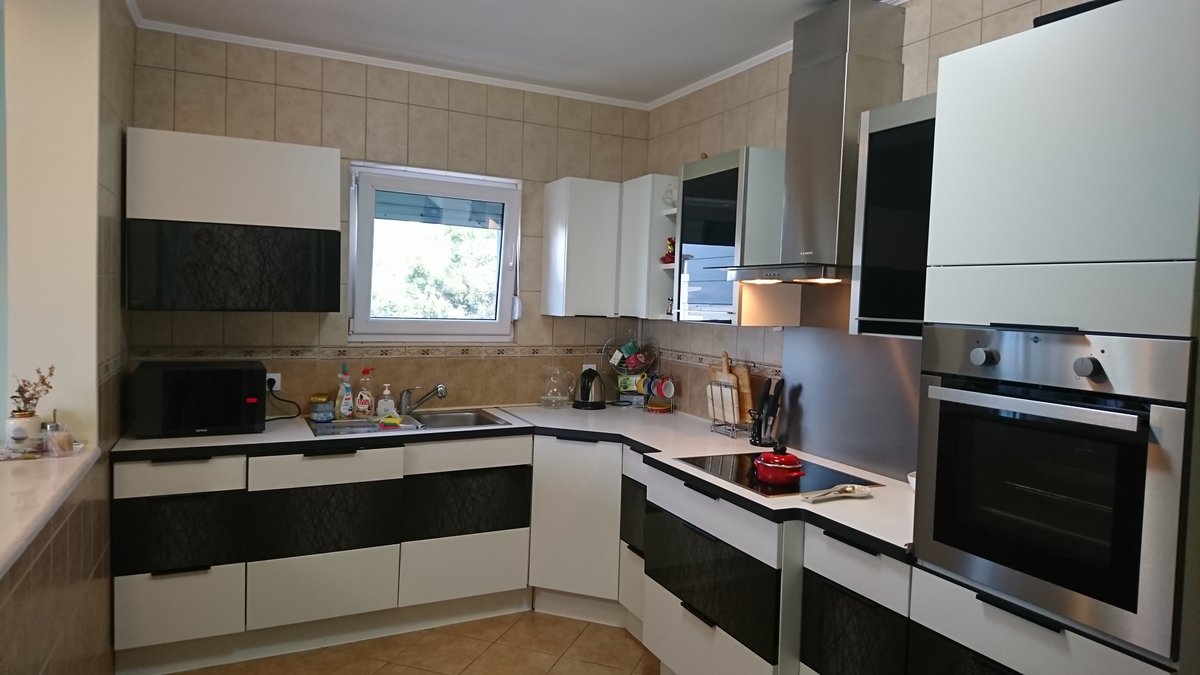 Moderne Küche im Schwarz-Weiß-Stil in einer Villa in Uteha, Montenegro: Einbaugeräte, Fliesen und helles Interieur.
