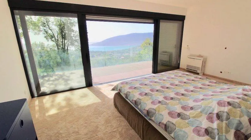 Schlafzimmer in einer Villa in Herceg Novi, Montenegro: Panoramafenster mit Meerblick, Terrasse und modernes Interieur.