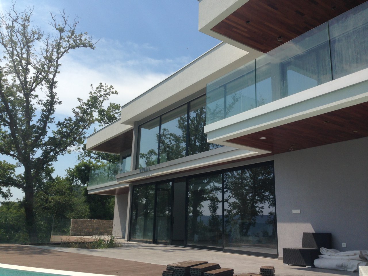 Hersek Novi, Karadağ’da panoramik pencereleri ve terası olan modern villa: cephe ve havuz manzarası.
