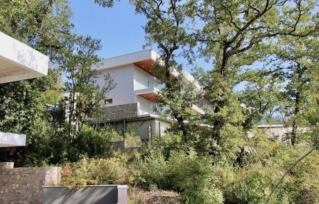 Karadağ, Herceg Novi’de modern villa: taş kaplamalı cephe, panoramik balkonlar ve yeşil bahçe.