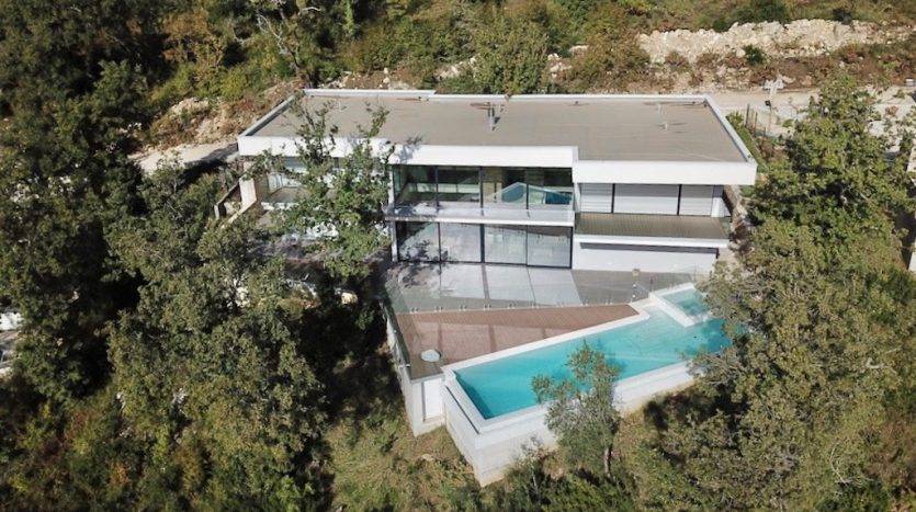 Panoramik pencereleri ve havuzuyla yeşillikler içinde modern villa, Herceg Novi, Karadağ. Havadan görünüm.