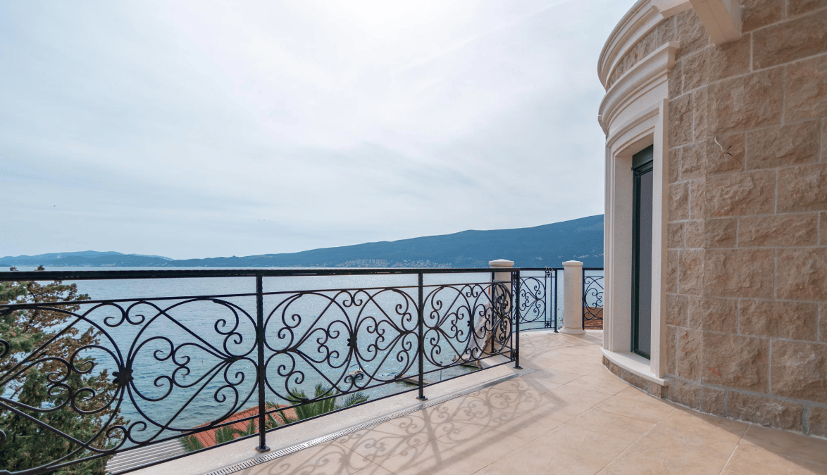 Przestronny taras willi w Bijeli, Czarnogóra, z kutą balustradą i panoramicznym widokiem na morze i góry.