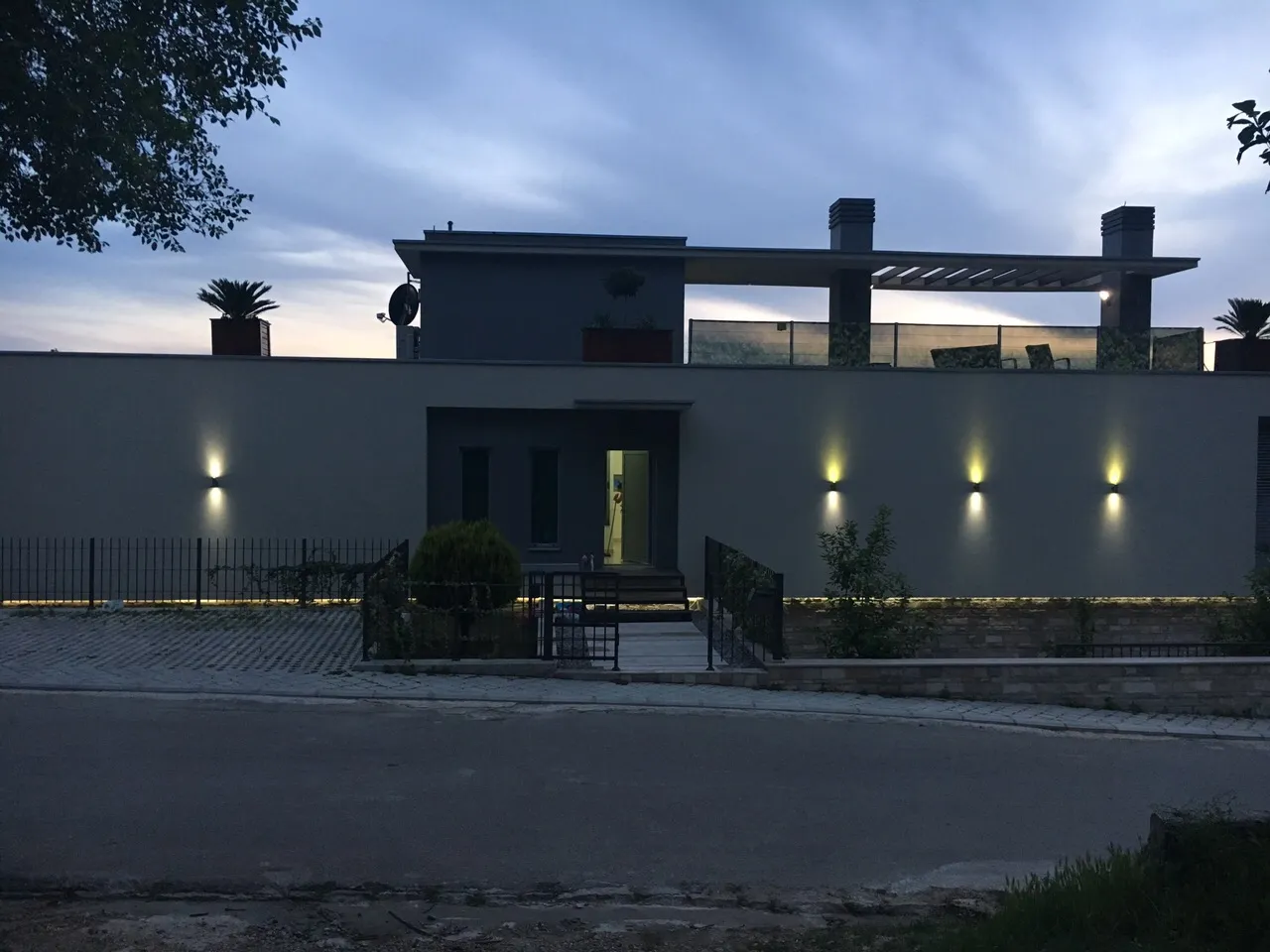 Vorderansicht eines modernen Hauses in der Dämmerung mit Beleuchtung.