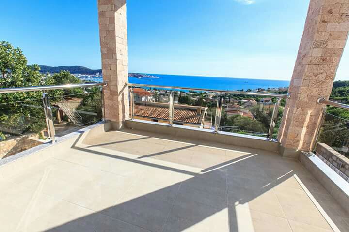 Geräumige Terrasse mit Panoramablick auf das Meer in einem Haus, Šušanj, Montenegro: Steinsäulen und Glasgeländer.