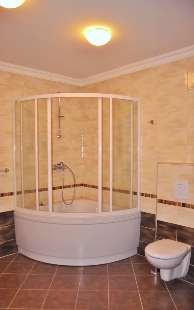 Bathroom with a corner shower cabin in a villa in Đenovići, Montenegro: light tiles and modern fixtures.