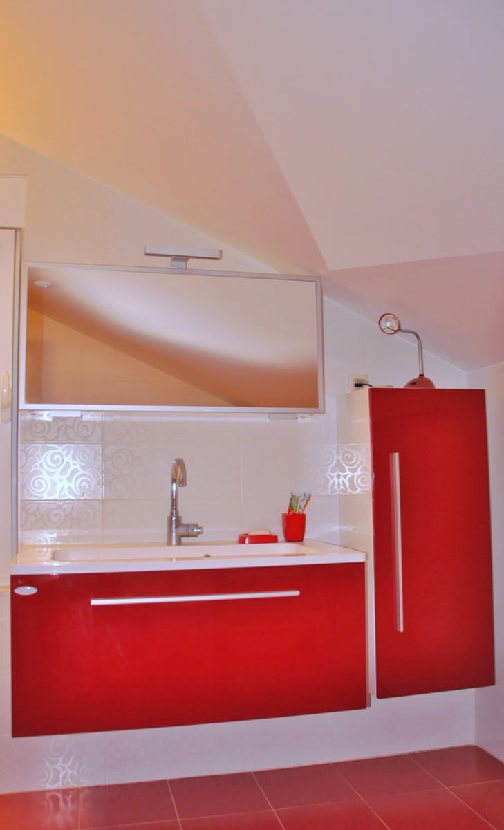 Bathroom with red furniture and mirror in a villa in Đenovići, Montenegro: modern finishes and plumbing fixtures.