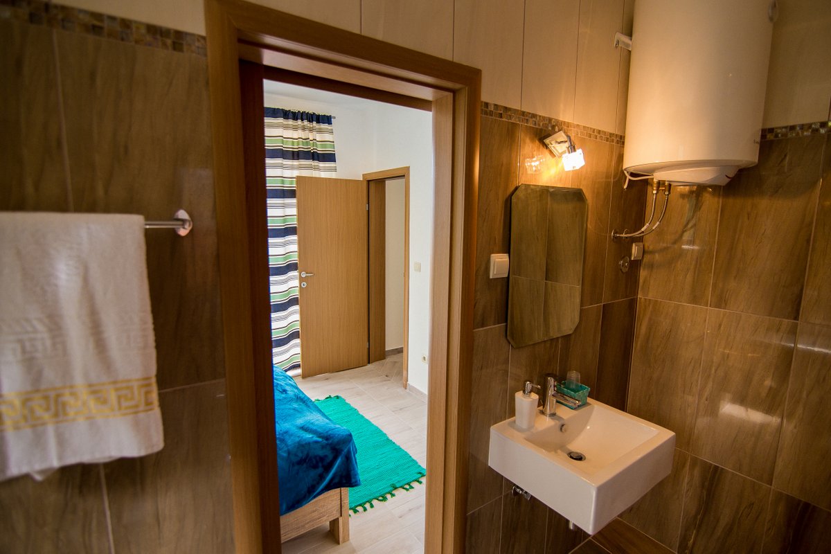Krašići, Karadağ’daki villada yatak odasına bakan kahverengi fayanslı banyo: sıhhi tesisat ve бойлер.