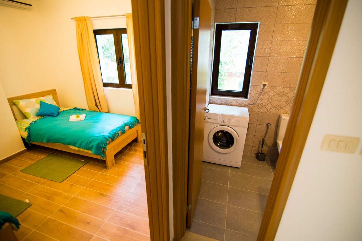 Krašići, Karadağ’daki villada yataklı yatak odası ve çamaşır makineli banyo.