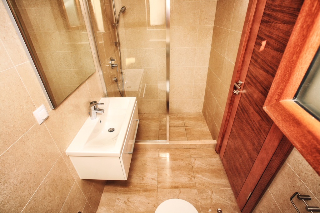 Karadağ, Herceg Novi’deki villada duş kabinli modern banyo: beyaz sıhhi tesisat ve bej fayans.