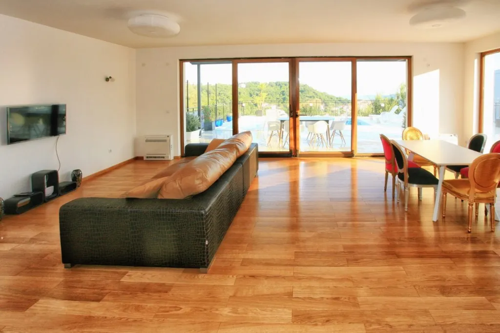 Geräumiges Wohnzimmer mit Sofa, großem Fenster und Essbereich