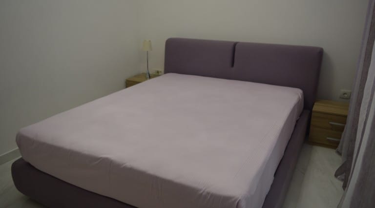 Cozy bedroom with a double bed and bedside tables in an apartment, village of Ljuta, Montenegro.