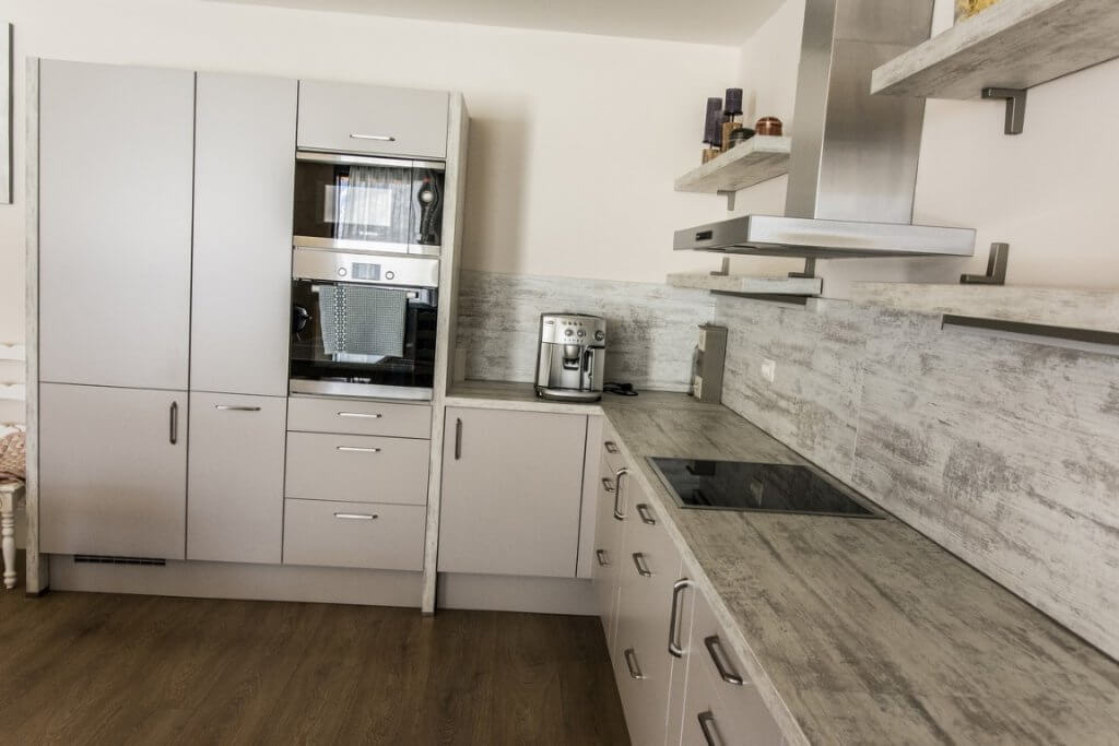 Moderne Küche mit eingebauten Geräten in einer Villa in Stoliv, Montenegro: helle Einbauküche und Arbeitsplatte in Holzoptik.