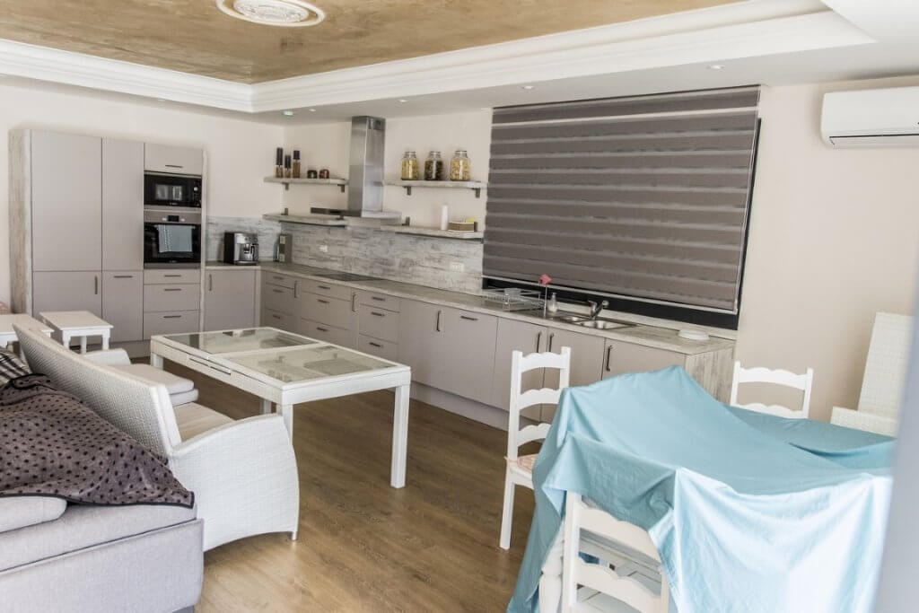 Moderne Wohnküche mit weißen Möbeln und integrierten Geräten in einer Villa in Stoliv, Montenegro.