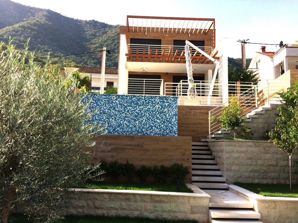 Moderne Villa in Stoliv, Montenegro: Fassade mit Terrasse, Pool, Steinverkleidung und Bergblick.