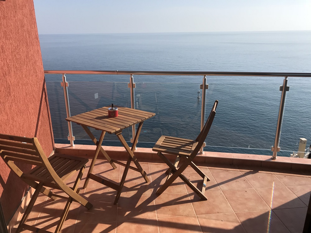 Balkon sa drvenim nameštajem i panoramskim pogledom na more u stanu, Dobri Vode, Crna Gora.