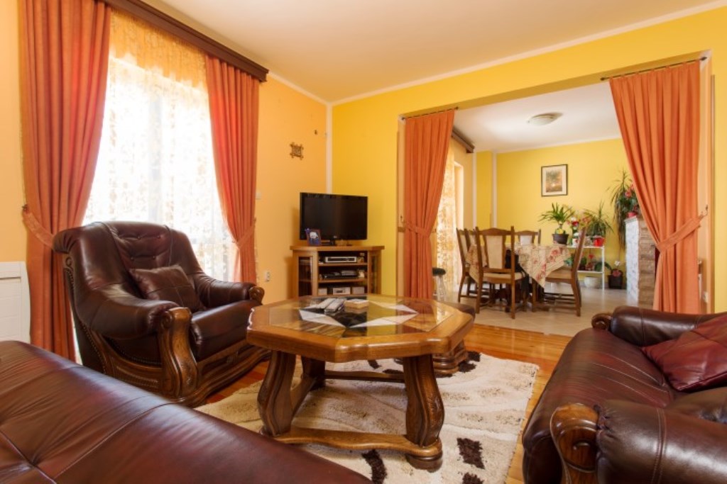 Wohnzimmer in einem Haus in Bijela, Montenegro: Ledermöbel, ein Holzcouchtisch und ein Essbereich mit hellem Interieur.