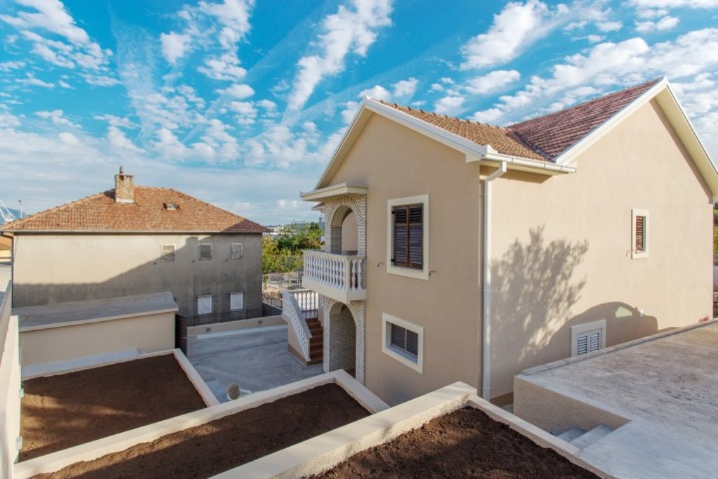 Zweistöckiges Haus in Bijela, Montenegro: Fassade mit Terrasse, Ziegeldach und gepflegtem Grundstück.