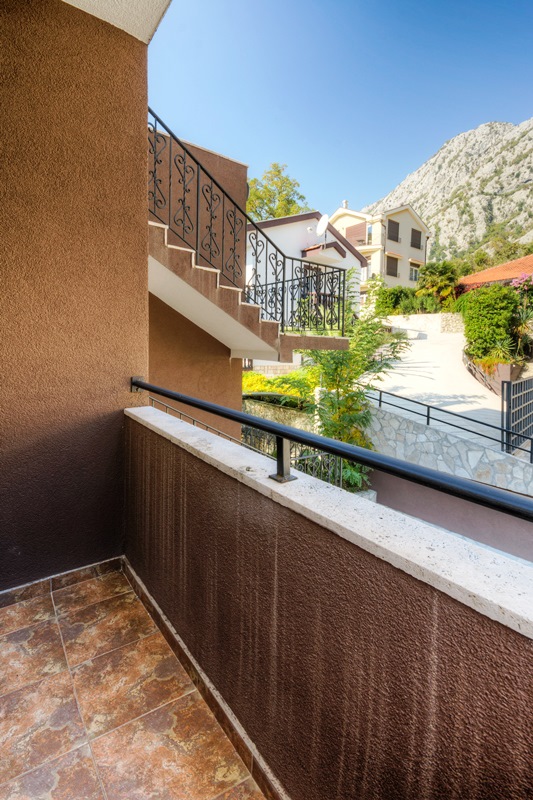 Balkon stana u Orahovcu, Crna Gora, sa pogledom na planine, kovanom ogradom i terakota pločicama na podu.