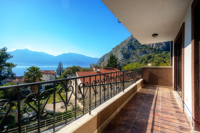 Prostran balkon sa kovanom ogradom i pogledom na more i planine u stanu, Orahovac, Crna Gora.