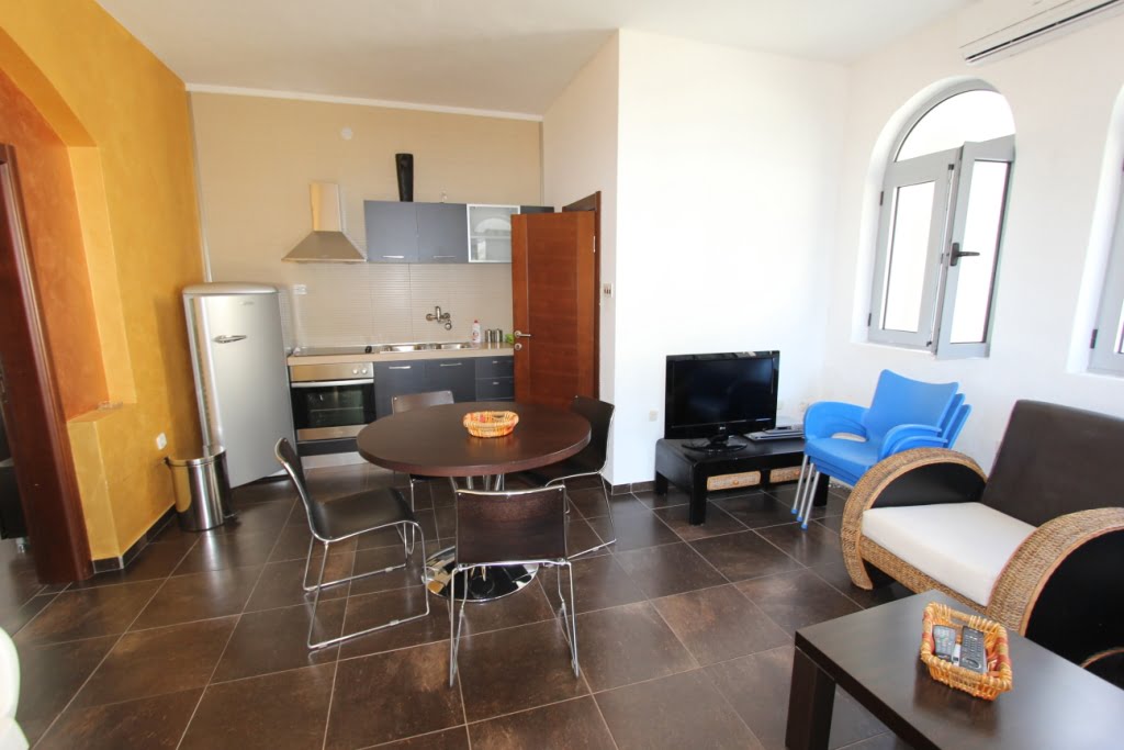 Salon z kuchnią w mini-hotelu, Orahovac, Czarnogóra: jadalnia, nowoczesne meble i łukowe okna.