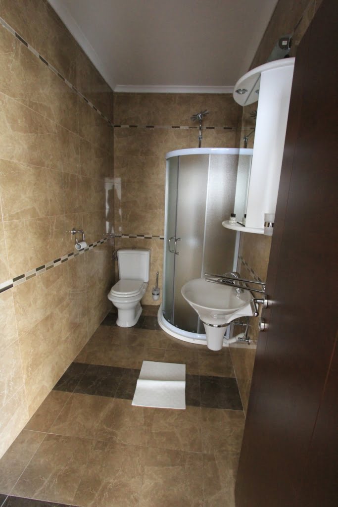 Łazienka z kabiną prysznicową w mini-hotelu, Orahovac, Czarnogóra: wykończenie płytkami imitującymi marmur, armatura sanitarna.