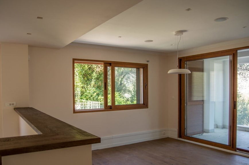 Bright living room with wooden windows and access to the terrace in a villa, Stoliv, Montenegro. Modern interior.