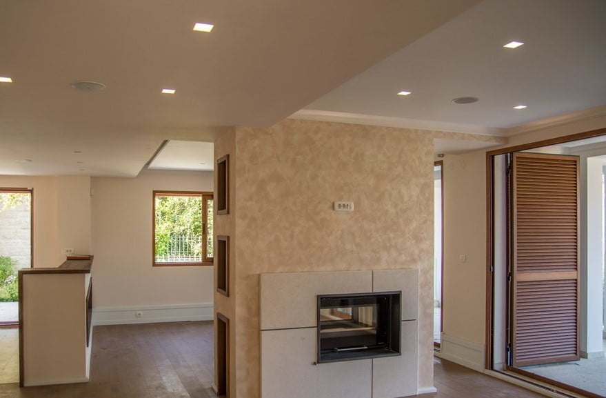 Living room with a fireplace and panoramic windows in a modern villa, Stoliv, Montenegro: stylish interior and finishes.