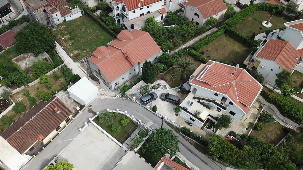 Karadağ, Prčanj’daki villanın havadan görünümü: kiremit çatılı, otoparklı ve yeşil alanlı özel ev.