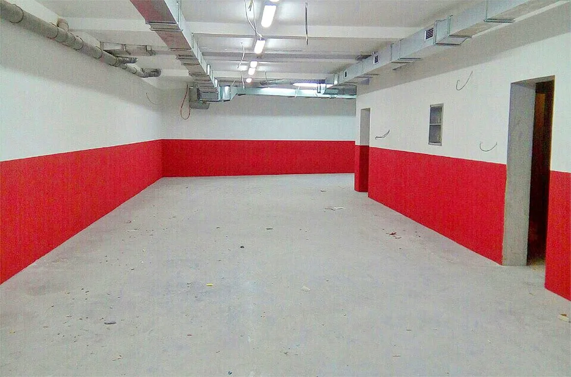 Freie Gewerbefläche zum Ausbau in Kotor, Montenegro, mit offenen Leitungen und Betonboden.