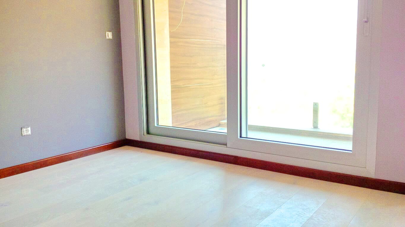 Helles Wohnzimmer mit Panoramafenster und Zugang zur Terrasse in einer Wohnung, Kotor, Montenegro. Moderne Innenausstattung.