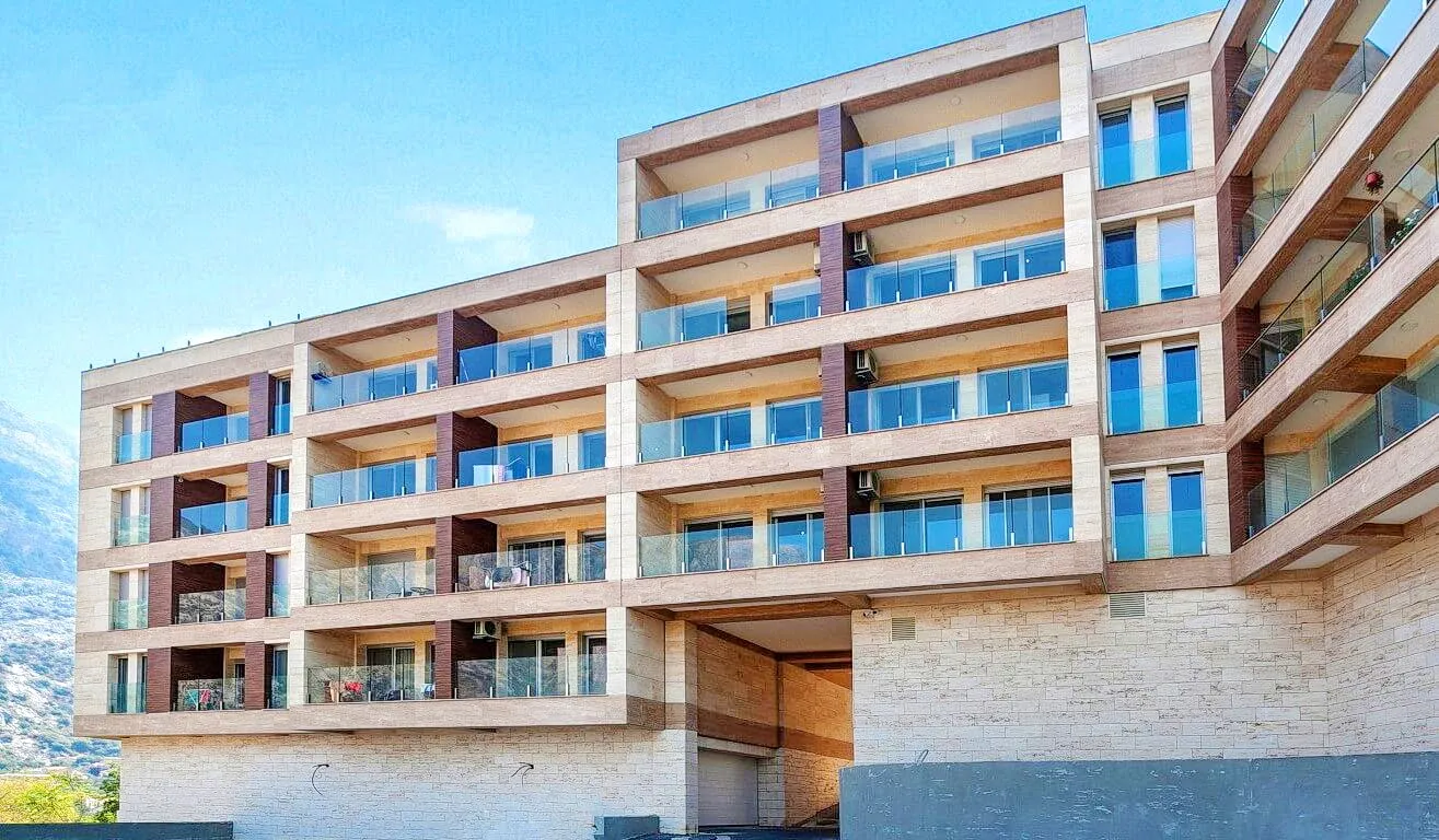 Moderner Wohnkomplex mit Balkonen und Steinverkleidung der Fassade in der Bucht von Kotor, Montenegro.