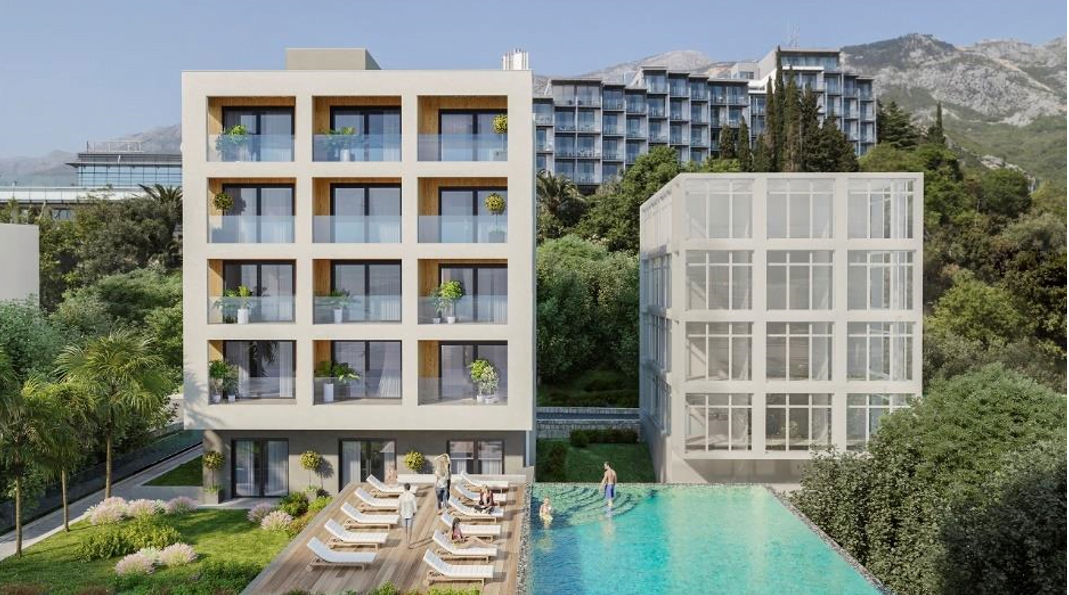 Becici, Karadağ’da havuzlu ve teraslı modern konut kompleksi: binanın cephesi ve yeşil alan manzarası.